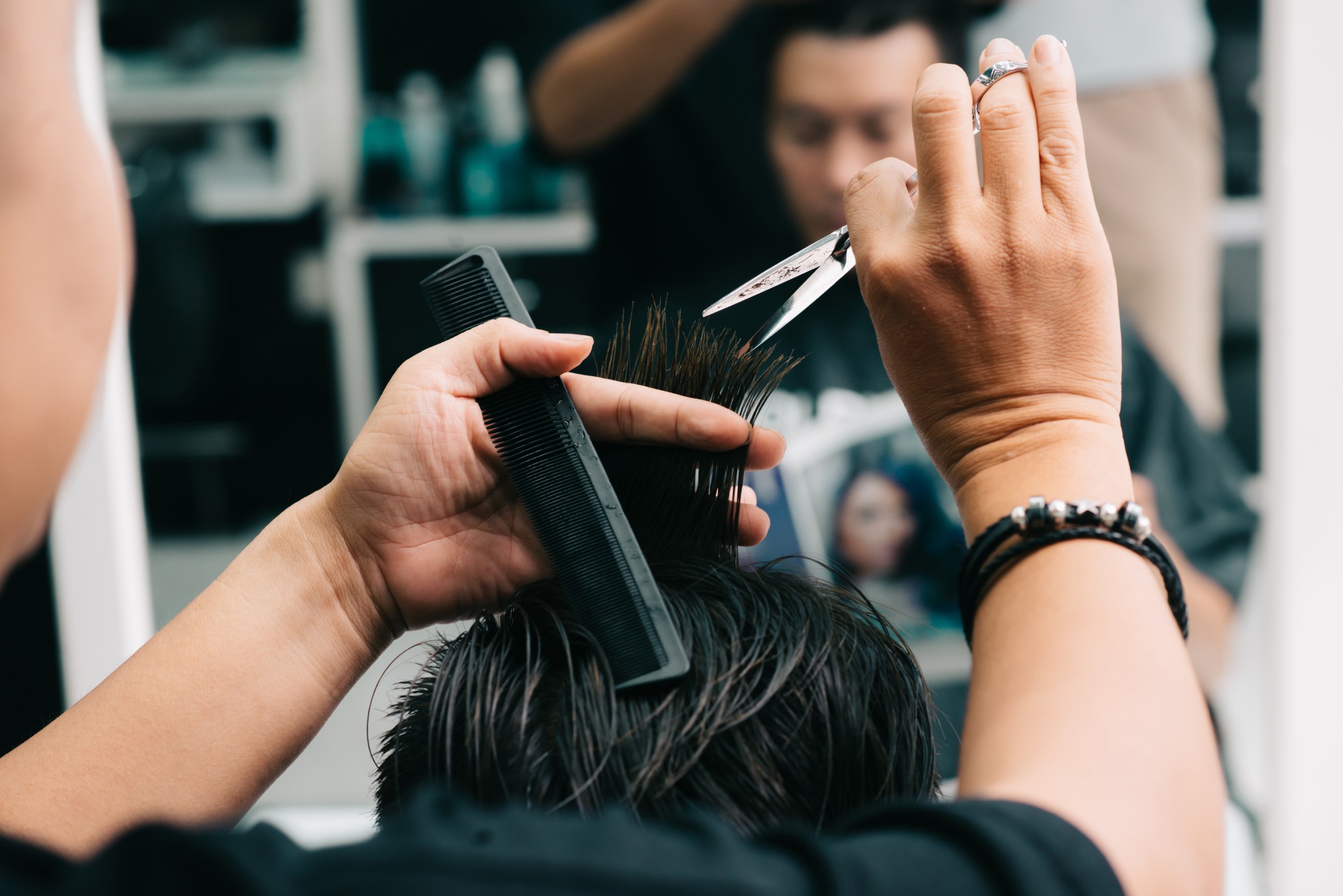 coiffeur barbier professionnel procédant à une coupe sur un homme
